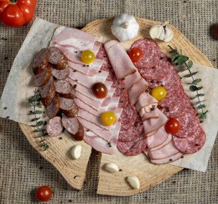 A flavorful assortment of meats and vegetables displayed on a rustic board.