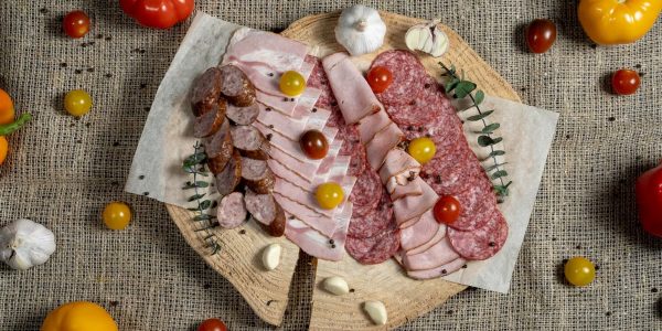 A flavorful assortment of meats and vegetables displayed on a rustic board.
